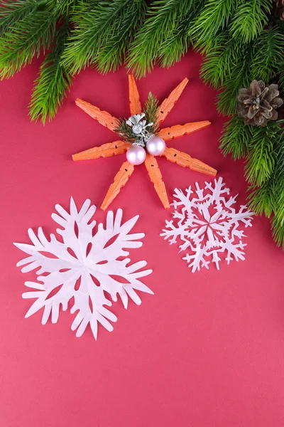 Schöne Schneeflocken mit Tannenzweig auf rosa Hintergrund — Stockfoto