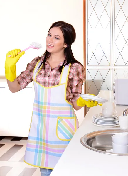 Όμορφη νεαρή γυναίκα, πλύσιμο των πιάτων στην κουζίνα — Φωτογραφία Αρχείου