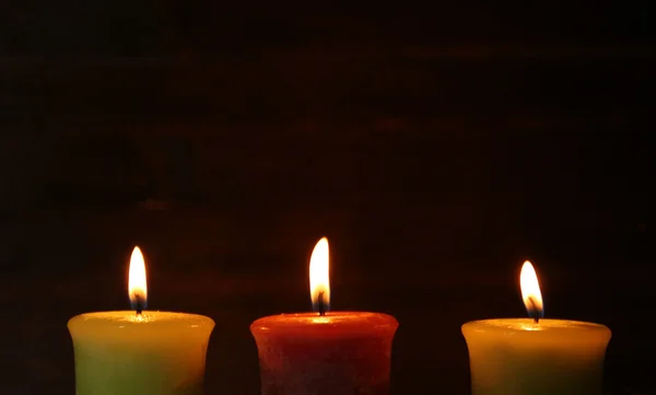 Hořící svíčky na dřevěném pozadí — Stock fotografie