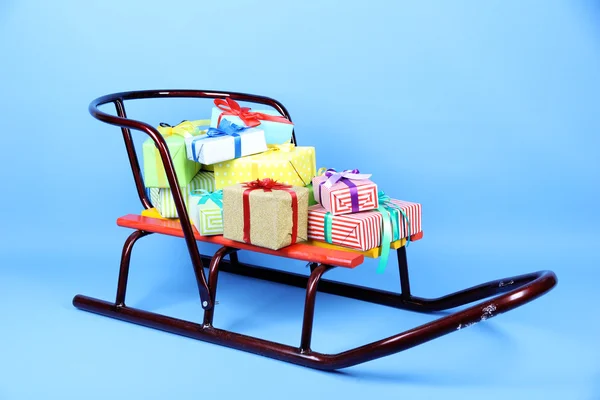 Sledge with Christmas presents, on blue background — Stock Photo, Image