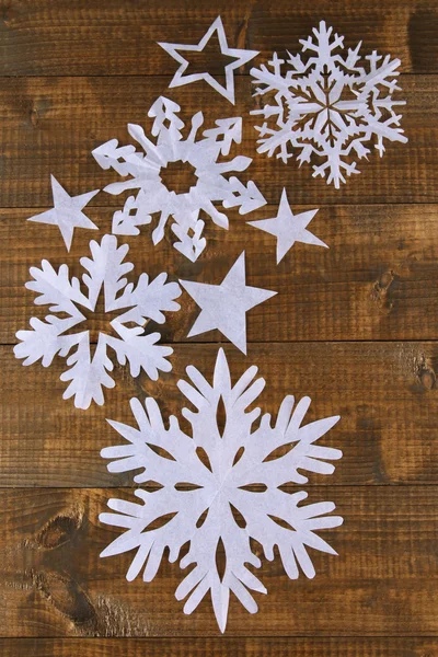 Hermosos copos de nieve de papel sobre fondo de madera — Foto de Stock