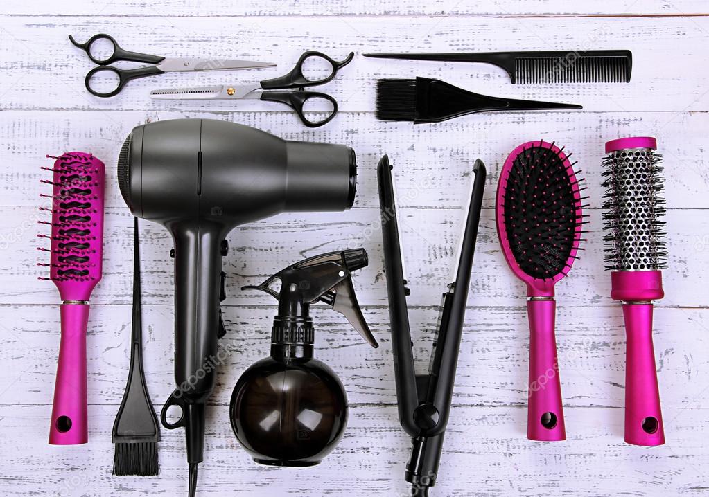 Hairdressing tools on white wooden table close-up
