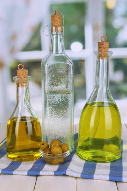 Özgün cam şişeler penceresi arka plan üzerinde ahşap masa üstünde salata sosu ile