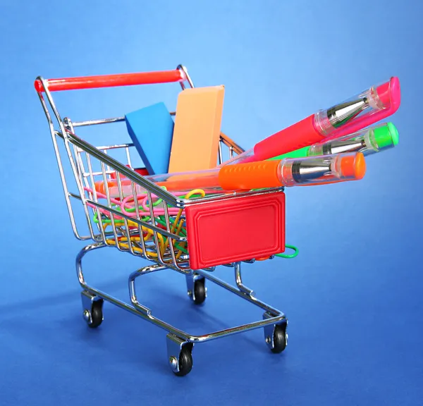 Trolley mit Schulausrüstung auf blauem Hintergrund — Stockfoto