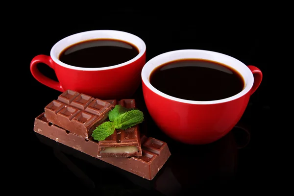 Czerwone kubki silne barów kawy i czekolady na czarnym tle — Zdjęcie stockowe