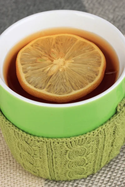 La taza del té con la cosa tejida en él se acercan —  Fotos de Stock