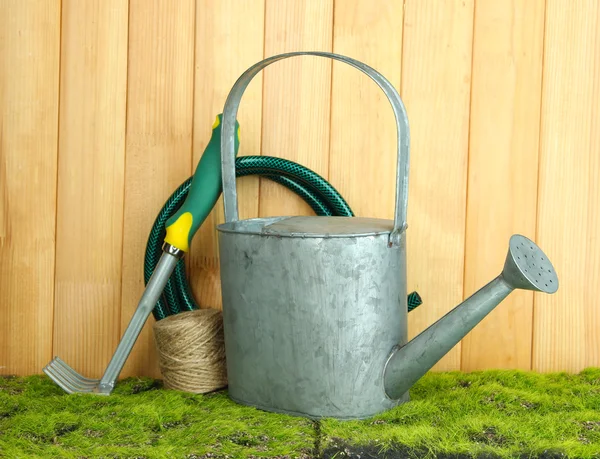 Gartengeräte auf Gras auf Holzgrund — Stockfoto