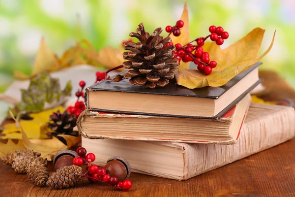 Livres et feuilles d'automne sur table en bois sur fond naturel — Photo