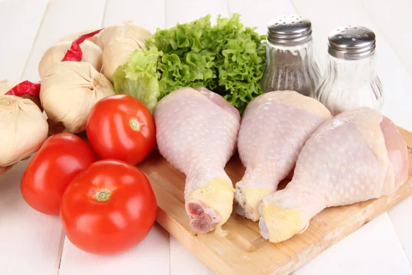 Raw chicken legs on wooden board close up — Stock Photo, Image