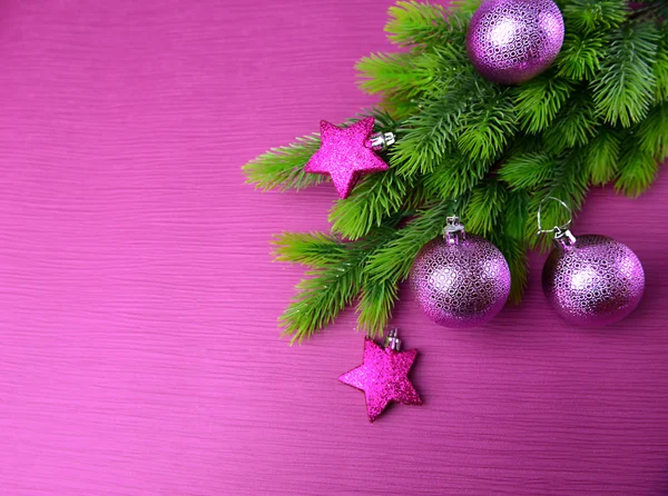 Kerstballen op fir boom, op een achtergrond met kleur — Stockfoto