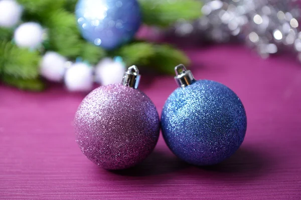 Christmas balls on fir tree, on color background — Stock Photo, Image