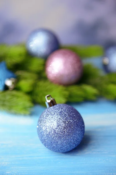 Christmas balls on fir tree, on color background — Stock Photo, Image