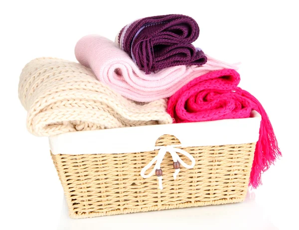 Warm knitted scarves in basket isolated on white — Stock Photo, Image