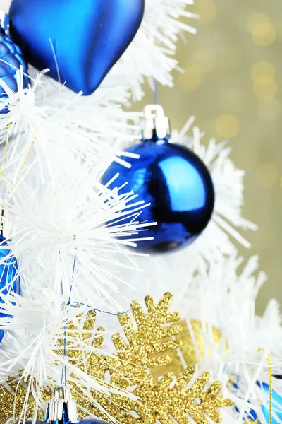 Spielzeug am Weihnachtsbaum auf hellem Hintergrund — Stockfoto