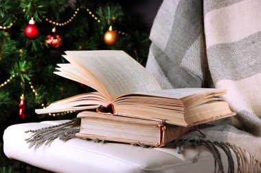 samenstelling met boeken en plaid op stoel op kerstboom achtergrond