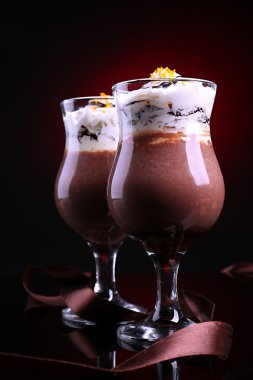 koyu renk arka plan üzerinde çikolata, krema ve portakal soslu lezzetli tatlı