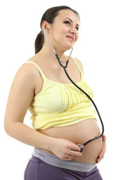 Young pregnant woman with stethoscope listening baby isolated on white — Stock Photo, Image