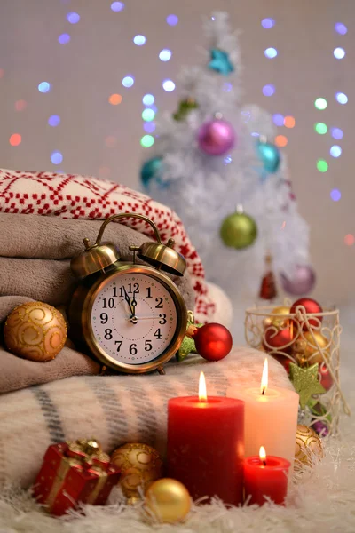 Composition with plaids, candles and Christmas decorations, on white carpet on bright background — Stock Photo, Image