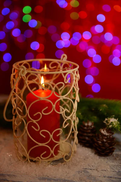 Vela e broto de árvore de Natal na mesa de madeira no fundo brilhante — Fotografia de Stock