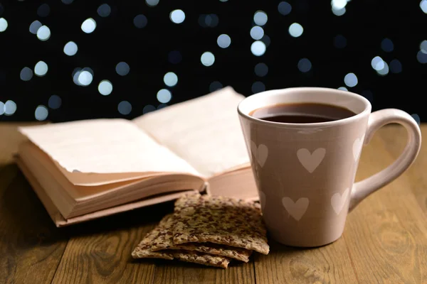 Samenstelling van boek met kop koffie op tafel op donkere achtergrond — Stockfoto