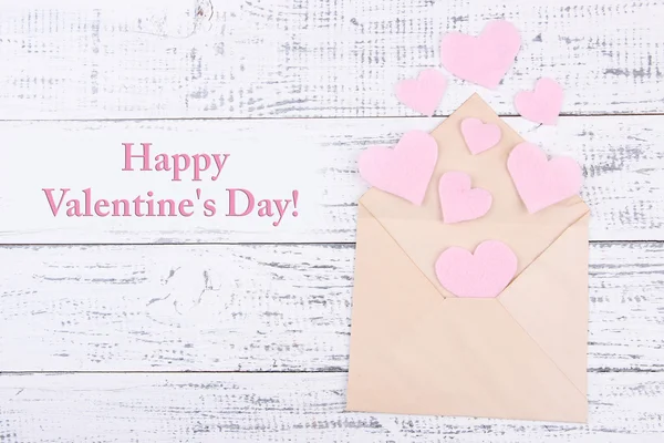 Beautiful old envelope with decorative hearts on wooden background — Stock Photo, Image