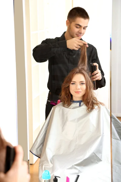 Cabeleireiro jovem fazer penteado menina no salão de beleza — Fotografia de Stock