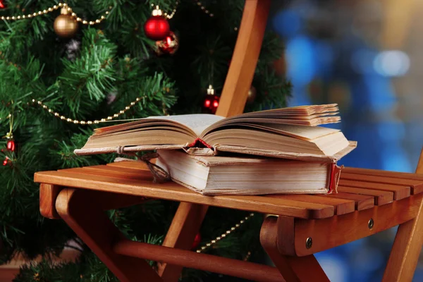 Složení s knihami na židli na vánoční stromeček pozadí — Stock fotografie