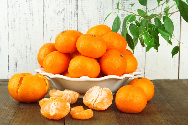 Reife Mandarinen in Schüssel auf Tisch auf Holzgrund — Stockfoto