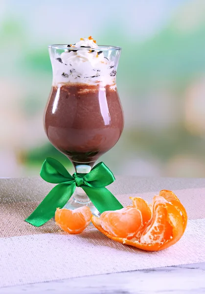 Sobremesa saborosa com chocolate, creme e molho de laranja, em guardanapo. na mesa de madeira, no fundo claro — Fotografia de Stock