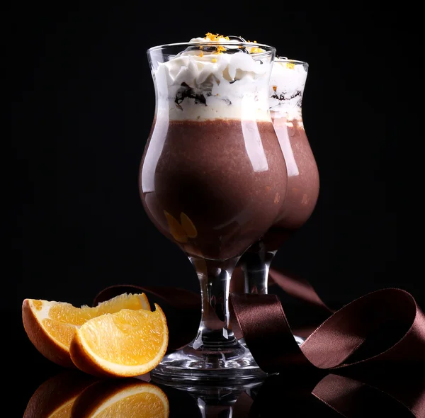 Sabroso postre con chocolate, crema y salsa de naranja, aislado en negro — Foto de Stock