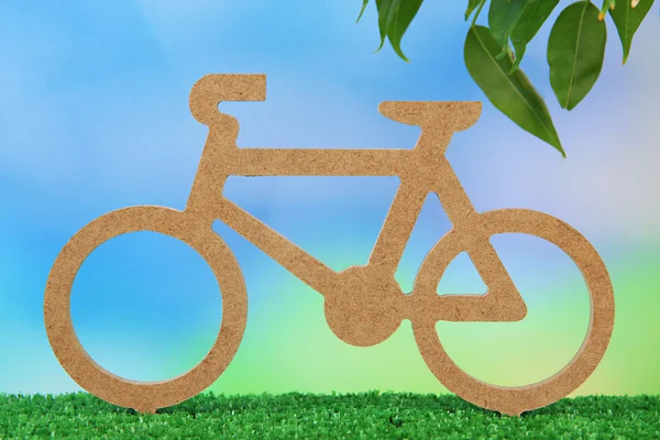 Dekoratives Fahrrad auf Gras auf hellem Hintergrund — Stockfoto