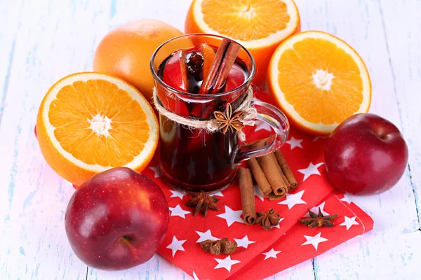 Fragrant mulled wine in glass on napkin and wooden table close-up — Stock Photo, Image