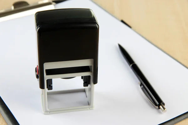 Stamp and clipboard on table — Stock Photo, Image