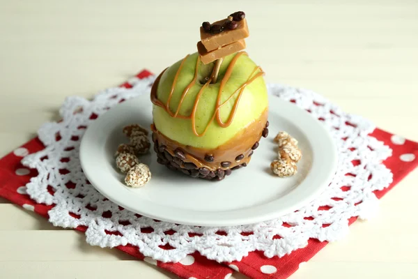 Homemade taffy apple, on napkin, on wooden table background — Stock Photo, Image