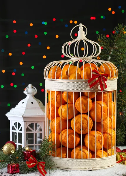 Tangerinas em gaiola decorativa com decoração de Natal, em fundo brilhante — Fotografia de Stock