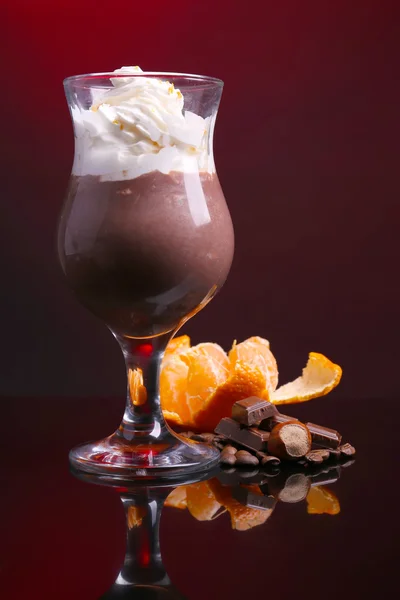 Lekker dessert met oranje, chocolade en crème saus, op donkere kleur achtergrond — Stockfoto