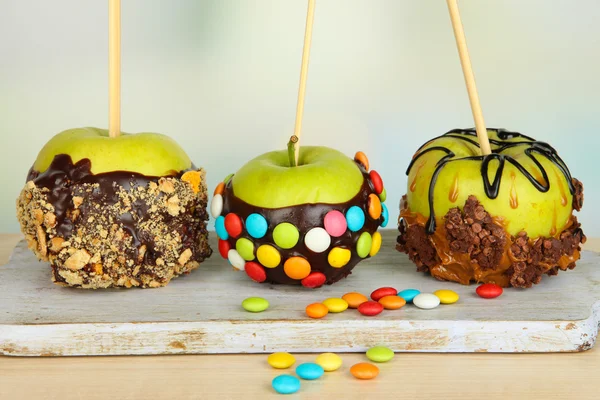Candied apples on sticks on bright background — Stock Photo, Image