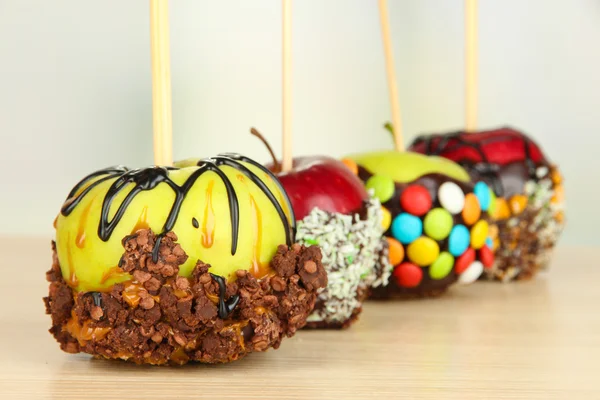 Candied apples on sticks on wooden table close up — Stock Photo, Image