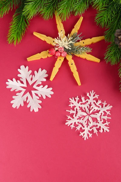 Belos flocos de neve com ramo de abeto no fundo rosa — Fotografia de Stock