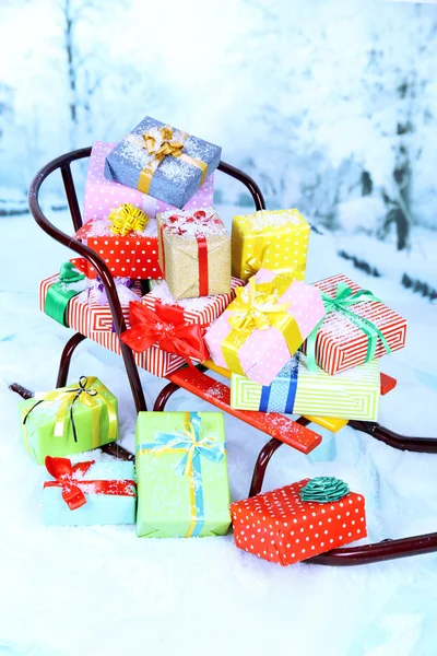Saně s vánoční dárky, na zimní pozadí — Stock fotografie