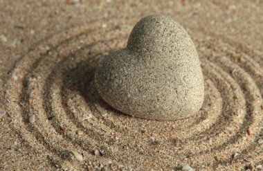 Gri zen stone kum arka plan üzerinde kalp şeklinde