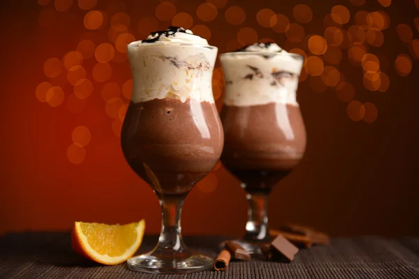 Lekker dessert met oranje, chocolade en crème saus, op tafel, op lichten achtergrond — Stockfoto