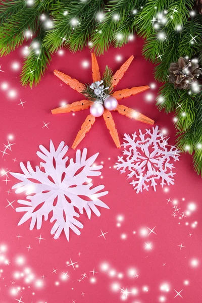 Beautiful snowflakes with fir branch on pink background — Stock Photo, Image