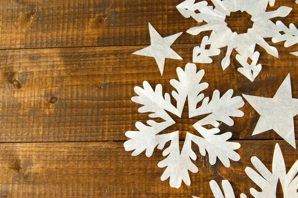 Hermosos copos de nieve de papel sobre fondo de madera — Foto de Stock