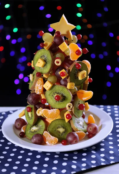 Árbol de Navidad de frutas en la mesa sobre fondo oscuro — Foto de Stock