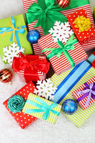 Many colorful presents with luxury ribbons on color carpet background — Stock Photo, Image