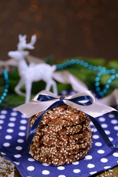 Heerlijke kerstkoekjes in pot op tafel op bruine achtergrond — Stockfoto