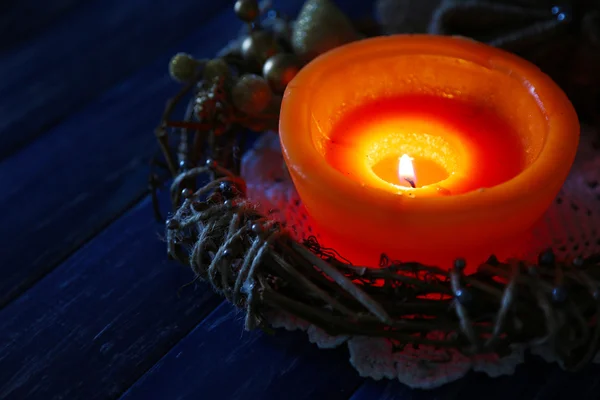 Vela ardiente con decoraciones navideñas sobre fondo de madera de color — Foto de Stock