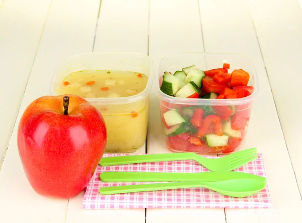 Tasty lunch in plastic containers, on wooden background — Stock Photo, Image