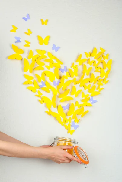 Paper yellow butterfly in form of heart fly out bank — Stock Photo, Image